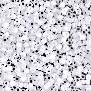 May include: A close-up image of a large quantity of small, white, square seed beads. The beads are opaque and have a slightly frosted finish.
