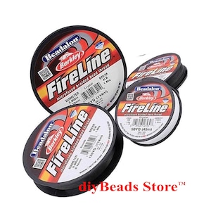 May include: Three round black spools of Beadalon Berkley FireLine microfused braided bead thread. The labels feature red, white, and black graphics with text including Crystal and Smoke color variants, 4lb break strength, and lengths of 50yd and 125yd.