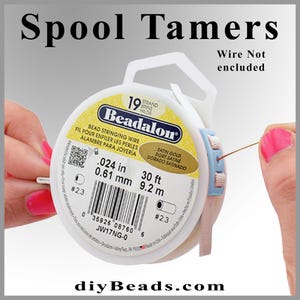 May include: A spool of Beadalon 19 strand satin gold bead stringing wire. The spool is white with blue and pink accents. The wire is 0.024 inches in diameter and 30 feet long. The spool is labeled with the brand name Beadalon and the product information. The spool is on a white background.