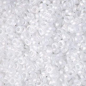 May include: A close-up view of a large quantity of small, white, plastic beads. The beads are shaped like rings with a small hole in the center.