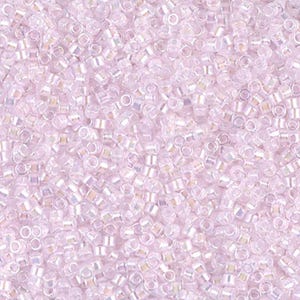 May include: A close-up view of a large quantity of small, iridescent, light pink seed beads. The beads are arranged in a random pattern, creating a shimmering effect.