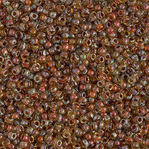 May include: A close-up image of a large quantity of small, round, brown glass beads with iridescent shimmer. The beads are arranged in a random pattern, creating a textured surface.