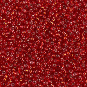 May include: A close-up view of numerous small, transparent red glass beads. Each bead has a small hole running through the center. The beads are scattered, creating a textured, vibrant surface. The beads are suitable for jewelry making and crafts.