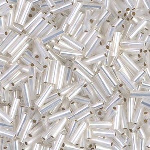 May include: A large quantity of small, white, glass beads in a tube shape. The beads have a shiny, iridescent finish.