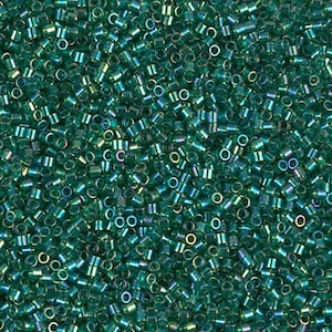 May include: A close-up view of a large quantity of small, round, teal-colored glass beads. The beads have a metallic sheen and are perfect for jewelry making.