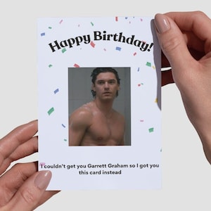 May include: A white rectangular greeting card featuring the text Happy Birthday in black arched lettering at the top, colorful confetti accents, a central photograph of a shirtless man, and the text I couldn't get you Garrett Graham so I got you this card instead at the bottom.