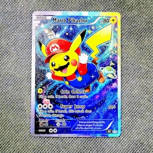 May include: A holographic Mario Pikachu trading card featuring a yellow character wearing a red hat with an M logo and blue overalls. The background displays a vibrant blue and purple galaxy with stars. Text includes Mario Pikachu, HP 80, Coin Collect, and Super Jump.