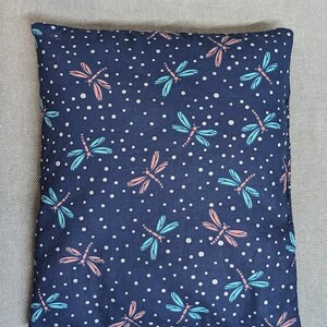 May include: A navy blue throw pillow with a white polka dot pattern and a repeating dragonfly design in shades of blue and pink.
