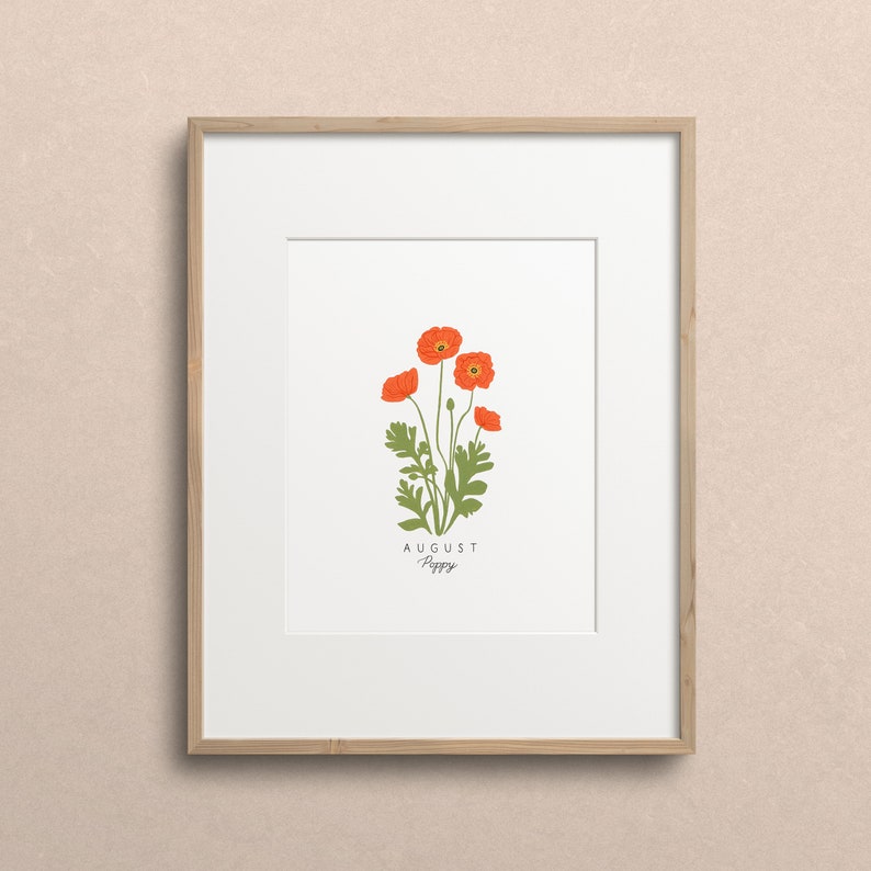 May include: A framed print with a white background featuring a botanical illustration of a poppy flower with the text "AUGUST Poppy" below the image.