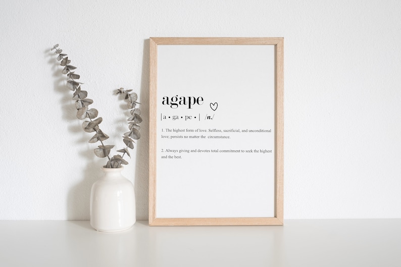 May include: A framed print with a black and white definition of the word "agape" which means "the highest form of love. Selfless, sacrificial, and unconditional love; persists no matter the circumstance. Always giving and devotes total commitment to seek the highest and the best."