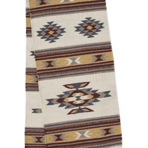 May include: A rectangular woven table runner featuring an off-white base with repeating geometric patterns in shades of mustard yellow, deep maroon, slate gray, and dark brown. The runner includes horizontal striped bands and tassels.