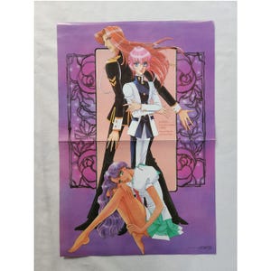 Puede incluir: Un póster de anime vintage con tres personajes de pelo largo. La figura central viste un uniforme blanco y azul marino. El fondo es morado con diseños florales y geométricos. El póster tiene un pliegue en el centro.