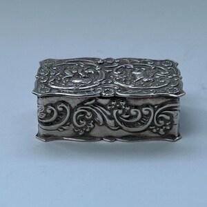 Putti English Sterling silver pill box, which is gilded inside. By OSS