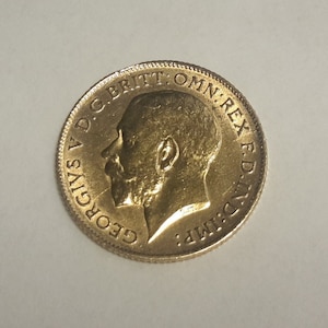 Könnte beinhalten: Goldmünze mit einem Profil von König Georg V und der Inschrift "GEORGIVS V D.G.BRITT:OMN:REX F.D."