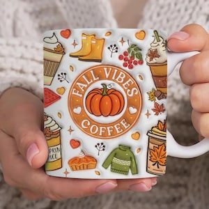 May include: White ceramic mug featuring a fall-themed design. The mug is decorated with images of coffee cups, pumpkins, leaves, and the text "FALL VIBES COFFEE". The mug is held by a person.