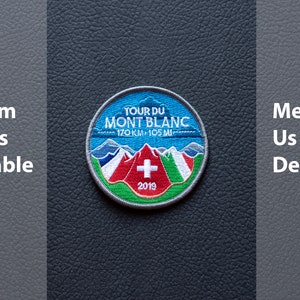 May include: Circular embroidered patch with the text "TOUR DU MONT BLANC 170 KM - 105 MI", featuring a mountain range, a Swiss flag, and the year 2019. The patch has a blue, white, red, and green colour scheme. The text "Custom Orders Available" and "Message Us For Details" are also present.