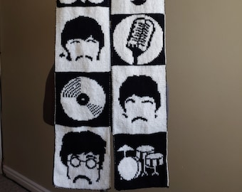 May include: Black and white knitted scarf with a pattern of four Beatles faces, a microphone, a record, and a drum set.
