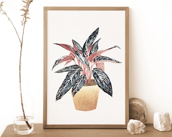 May include: A framed print of a watercolor painting of a houseplant with dark green and pink leaves in a gold pot.