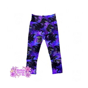 May include: Leggings with a repeating pattern of black dragons on a purple and blue galaxy background. The leggings have a high waistband and are made of a soft, stretchy material. The words "DO NOT COPY" are printed on the leggings.