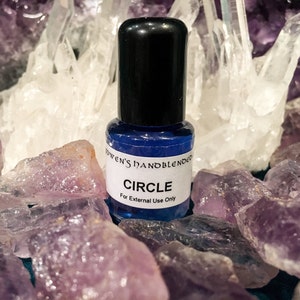 May include: A small blue glass bottle with a black cap. The bottle is labeled "YOWEN'S HANDBLENDER CIRCLE For External Use Only".