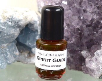 May include: A small brown glass bottle with a black cap. The bottle is labeled "Objets d'Art & Spirit SPIRIT GUIDE EXTERNAL USE ONLY".