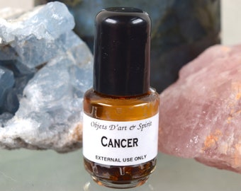 May include: A small brown glass bottle with a black cap and a white label that reads "Objets D'art & Spirit CANCER EXTERNAL USE ONLY".