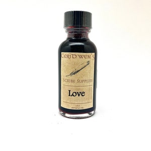 May include: A small glass bottle with a black cap and a brown label that says "Ceridwen's Scribe Supplies Love".