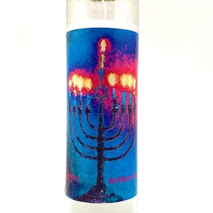 May include: A white candle with a blue and pink image of a menorah with the text "Happy Hanukkah" on the front.