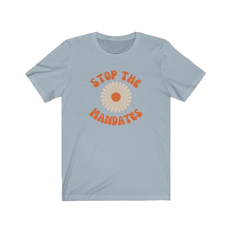 May include: Light blue t-shirt with a daisy graphic and the text "STOP THE MANDATES" in orange.