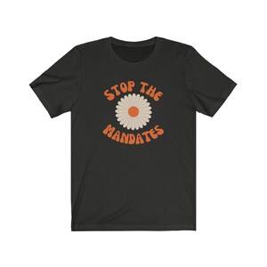 May include: Black t-shirt with a daisy graphic and the text "STOP THE MANDATES" in orange.