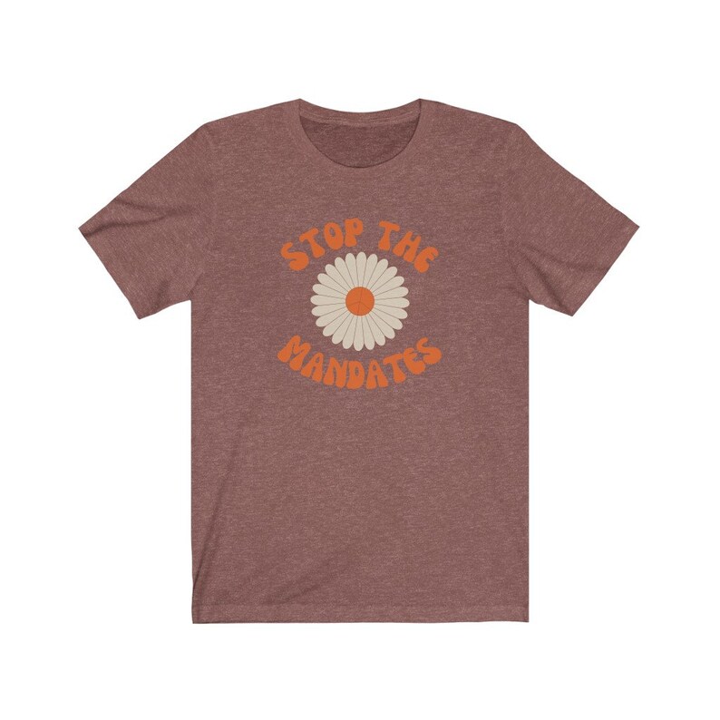 May include: A heather brown t-shirt with a daisy graphic and the text "Stop the Mandates" in orange.