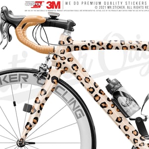 May include: A white and brown leopard print bicycle frame with black wheels and a black water bottle holder. The bicycle frame has the text "MRSTICKER CLING" on the side.