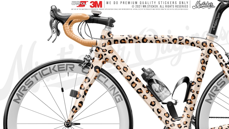 May include: A white and brown leopard print bicycle frame with black wheels and a black water bottle holder. The bicycle frame has the text "MRSTICKER CLING" on the side.