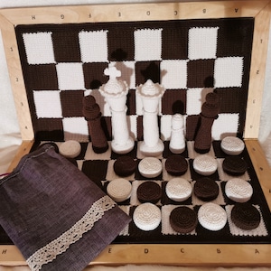 May include: A crocheted chessboard with white and brown squares, a brown bag, and white crocheted chess pieces. The board is labeled with letters A through H and numbers 1 through 8.