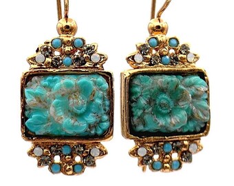 Puede incluir: Un par de pendientes de tono dorado con acentos de flores de baquelita azul turquesa. Los pendientes tienen una cadena de tono dorado y un diseño de flor de tono dorado con diamantes de imitación transparentes.