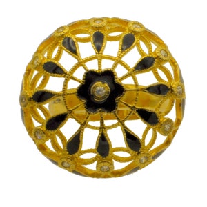 May include: A gold ring with a black enamel design. The ring is shaped like a sphere and has a delicate, intricate pattern. The design features small, clear stones.