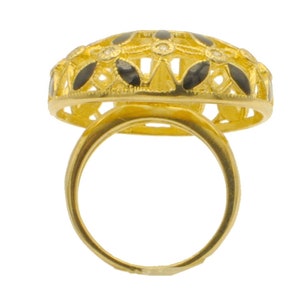 May include: A gold ring with a black and white filigree design. The ring is set with small white stones.