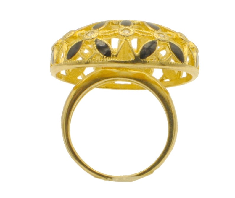 May include: A gold ring with a black and white filigree design. The ring is set with small white stones.