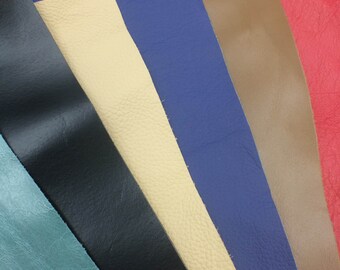 May include: A variety of leather swatches in different colors, including teal, black, beige, blue, brown, and red. The swatches are arranged in a fan shape, with the teal swatch at the bottom and the red swatch at the top.