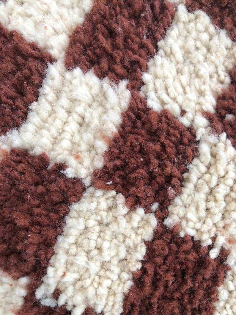 Peut inclure: Gros plan sur un tapis moelleux brun et blanc &agrave; motif &agrave; carreaux.
