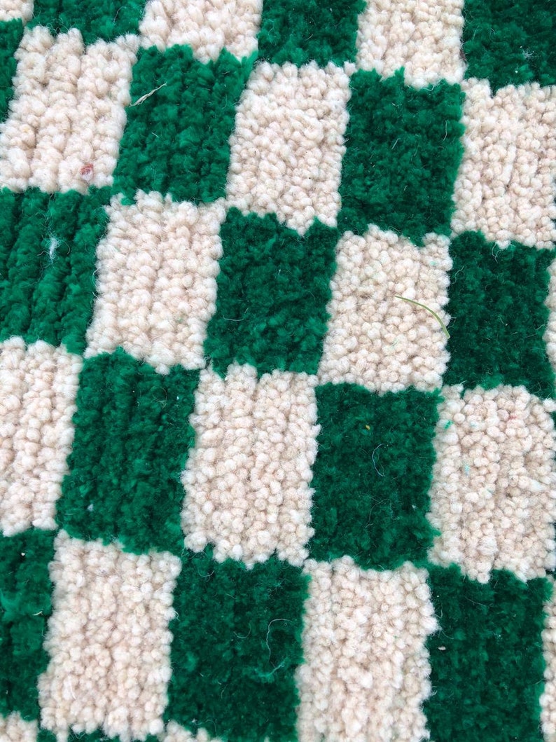 Peut inclure: Gros plan d'un tapis &agrave; carreaux avec des carr&eacute;s altern&eacute;s de tissu vert et cr&egrave;me. Le tapis est fait d'un mat&eacute;riau doux et moelleux.