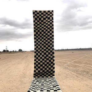 Peut inclure: Un tapis &agrave; carreaux noirs et blancs avec une bordure &agrave; franges. Le tapis est pos&eacute; sur un chemin de terre.
