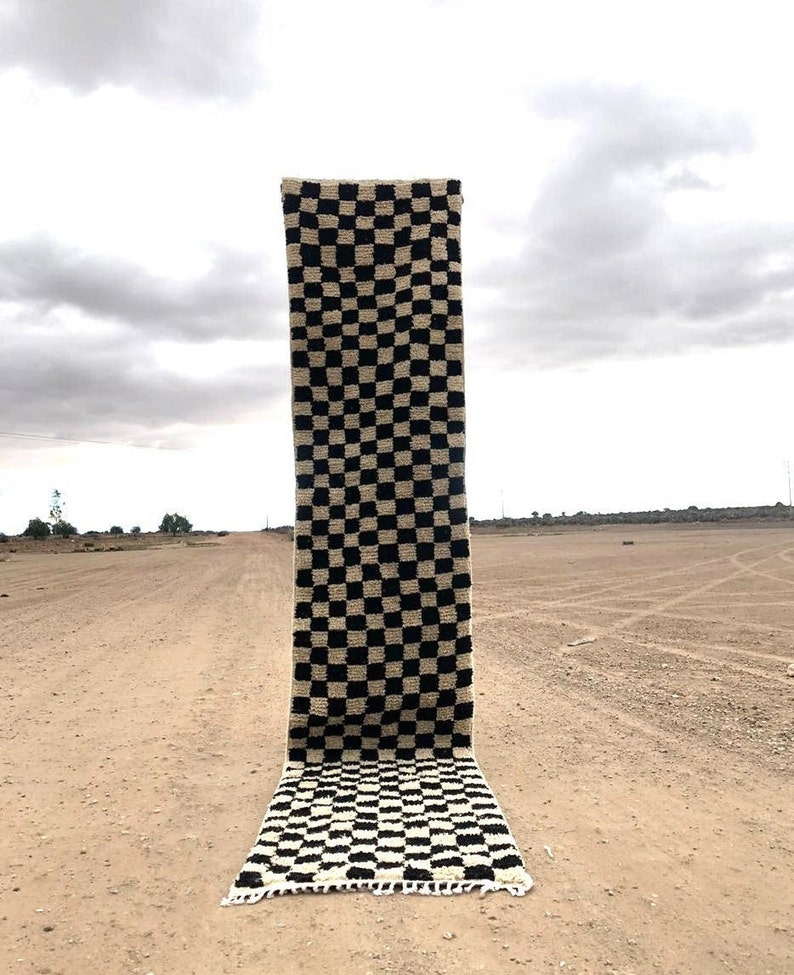 Peut inclure: Un tapis &agrave; carreaux noirs et blancs avec une bordure &agrave; franges. Le tapis est pos&eacute; sur un chemin de terre.