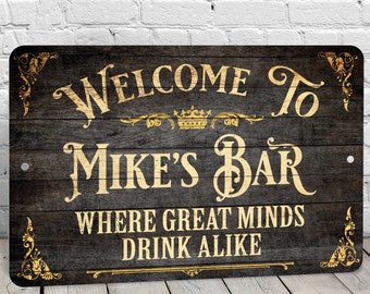 May include: A rustic wooden sign with gold accents reads "Welcome to Mike's Bar Where Great Minds Drink Alike".