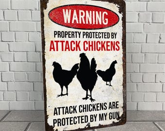 Op de afbeelding: Een waarschuwingsbord met een rode achtergrond en witte tekst die "WARNING PROPERTY PROTECTED BY ATTACK CHICKENS ATTACK CHICKENS ARE PROTECTED BY MY GUN" luidt. Het bord heeft een roestige metalen textuur en een silhouet van drie kippen.