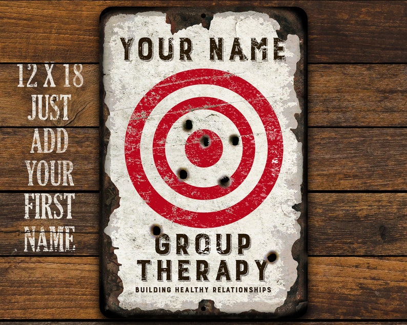 May include: A white metal sign with a red and white target in the center. The sign says "YOUR NAME GROUP THERAPY BUILDING HEALTHY RELATIONSHIPS".