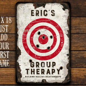 May include: A white metal sign with a red and white target in the center. The sign says "Eric's Group Therapy Building Healthy Relationships".
