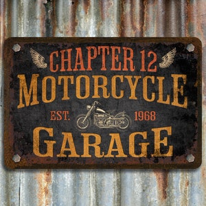 Pu&ograve; includere: Un cartello in metallo arrugginito con il testo "Chapter 12 Motorcycle Garage" in lettere arancioni e gialle. Il cartello include anche il testo "Est. 1968" e un'immagine in bianco e nero di una motocicletta.