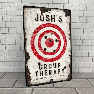 May include: A rustic metal sign with a red and white target and the text "Josh's Group Therapy Building Healthy Relationships".