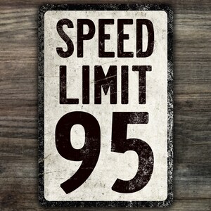 May include: A vintage-style speed limit sign with a white background and black text. The sign reads "SPEED LIMIT 95".